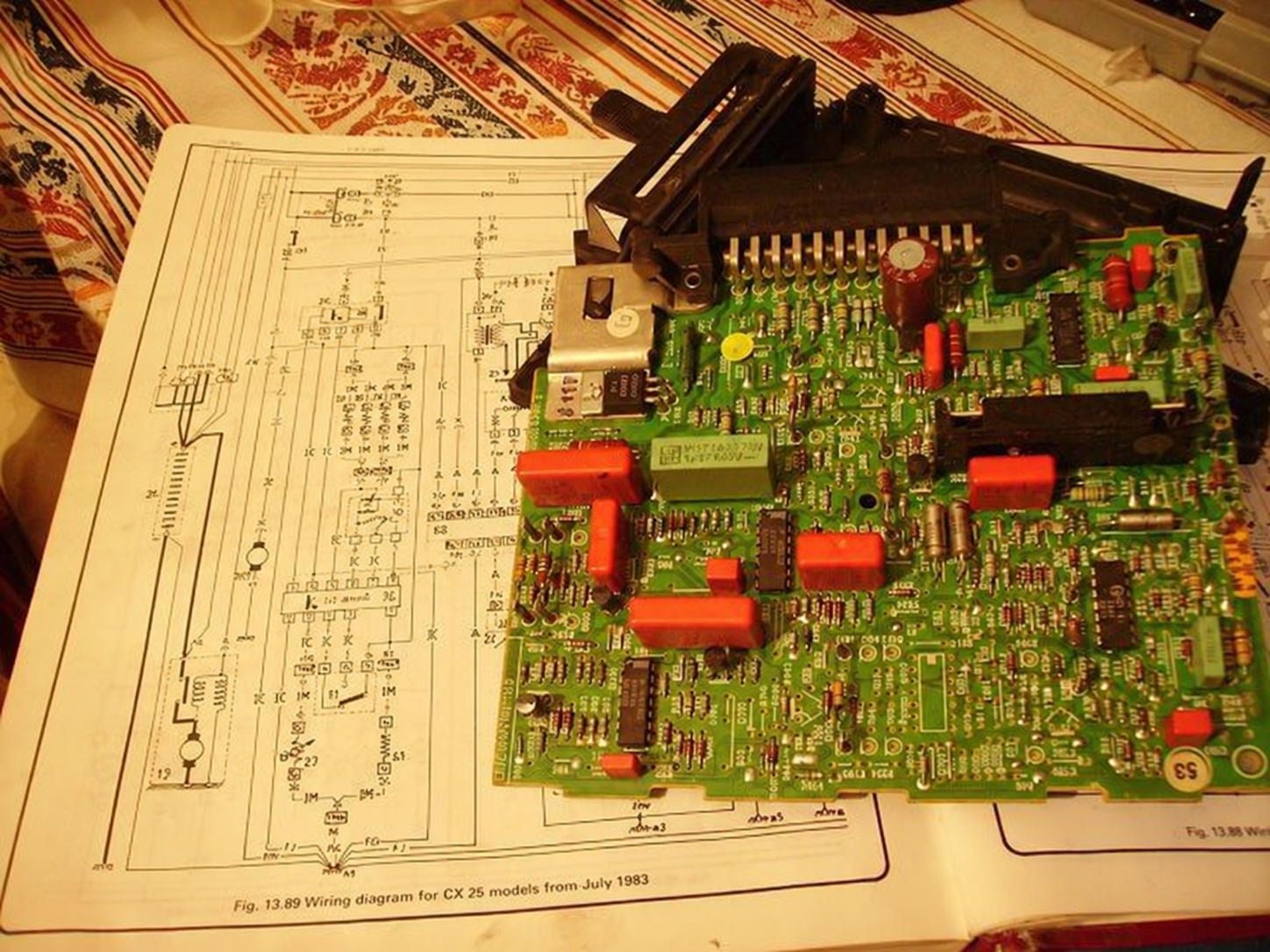 Placa electrónica abierta sobre un manual de circuitos